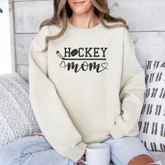 Thank you so much for supporting a small business! Please note that our Christmas deadline is 12/9. Order placed after that may not arrive on time, and we are not responsible for late arrivals due to carrier delays.The perfect cozy  hockey mom sweatshirt for hockey mom  it's made from a soft, mid-weight cotton-blend fabric for easy layering when it gets chilly or throw it on alone for comfort. Full of style and comfort, we think this sweatshirt has all the qualities that a hockey mama could ever Hockey Mom Cricut Ideas, Hockey Mom Shirts, Cricut Hockey Shirts, Hockey Sweater Cricut, Hockey Mom Sweatshirt Hoodie, Hockey Mom Gifts, Mom Apparel, Embroidery Decoration, Hockey Sweatshirts