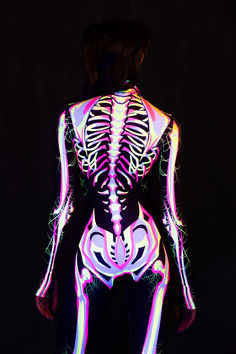 Embrace vibrant terror with this costume, blending a skeleton silhouette with bright, eye-catching patterns and spiderwebs peeking through the bones. The form-fitting suit bursts with colorful designs and delicate webs that stretch and twist, creating an eerie contrast between the lively hues and the haunting corpse. This look combines playful energy with a chilling undertone, making you a walking contradiction of life and darkness. Halloween Costumes Outfits, Skeleton Silhouette, Walking Contradiction, Bright Eye, Full Body Suit, Halloween Costume Outfits, The Haunting, Mock Neckline, Costume Outfits