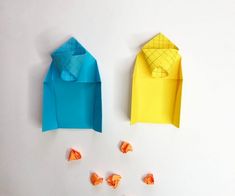 two origami pieces are next to each other on a white surface, one is blue and the other is yellow