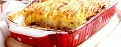 a person is holding a casserole dish in their left hand, with two forks on the side