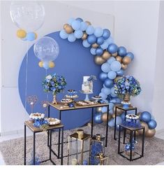 blue and gold party decorations with balloons on the wall, table set up for an event