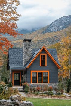 a gray house with orange trim in the mountains