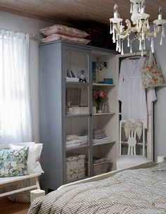 a bed room with a neatly made bed and a chandelier hanging from the ceiling