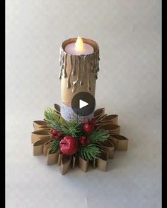 a candle that is sitting on top of some wrapping paper next to a christmas decoration