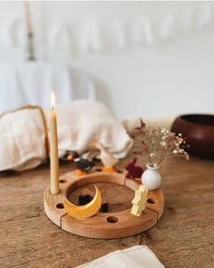 a wooden table topped with two candles and a crescent