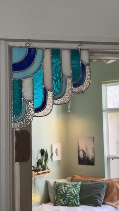 a living room filled with furniture and lots of stained glass pieces hanging from the ceiling