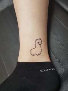 a small tattoo on the ankle of a woman's foot with a black sheep