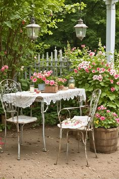 an outdoor table and chairs with flowers in the background