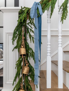 a bunch of bells hanging from the side of a banister next to a christmas tree