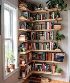 a bookshelf filled with lots of books next to a window in a room