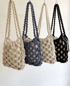 four crocheted bags hanging from hooks