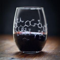 a glass filled with liquid sitting on top of a wooden table