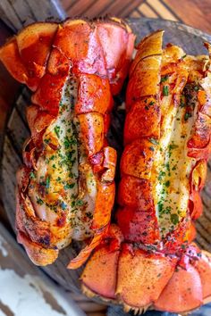 two lobsters are sitting on a plate with parsley sprinkled on them