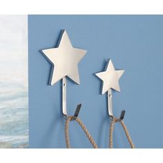 two white stars are hanging on the wall next to a rope and a blue background