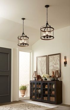 two lights hanging from the ceiling in a room with a rug and potted plant