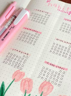 a pink pen sitting on top of a notebook