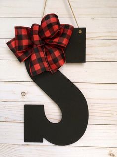 the letter s is decorated with a red and black plaid bow