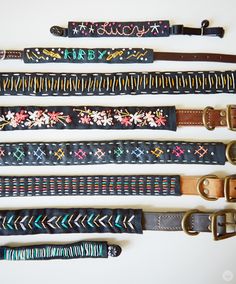 five different types of belts are lined up on a white surface, one is black and the other has multicolored designs