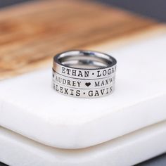 Bring tears to mom's eyes with this custom name ring.  If she is a new mom or a mom to many she will cherish this personalized ring.  I recommend DAKOTA BLUE font for the darkest engraving. This listing is for 1 ring engraved with names of your choice separated by hearts or dots.  Rings measure 3mm wide.  Available in whole ring sizes 4-10.  Available in stainless steel.   Engrave up to 30 characters. Your choice of font from the secondary font photo. Choose to space the names with hearts, dots, or none (just a space). Two rings can easily be stacked.  3 rings can be stacked if you like a chunkier feel on your finger.  4 rings is likely too many for most fingers and not recommended. I recommend sizing up if you are stacking them.  Be sure to have your finger sized before ordering.  Ask if Mom Ring, Name Ring, Engraved Ring, Name Rings, Engagement Ring White Gold, Kids Names, Great Gifts For Mom, Tiny Diamond, Rose Gold Engagement