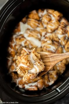 the crock pot is filled with cinnamon rolls and drizzled with icing