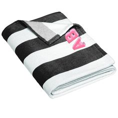 a black and white striped blanket with pink letters on the front, along with an embroidered bw logo