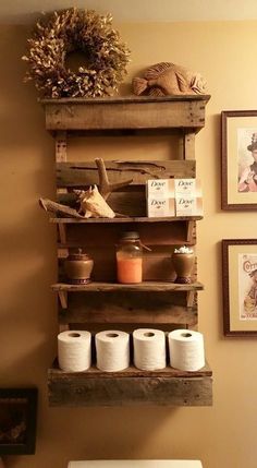 an old pallet shelf is used as a toilet paper holder in this rustic bathroom