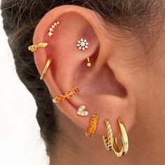 an ear with five different types of piercings on the top and bottom of it