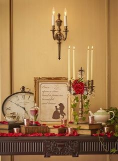 a mantle with candles, roses and other items on it in front of a clock