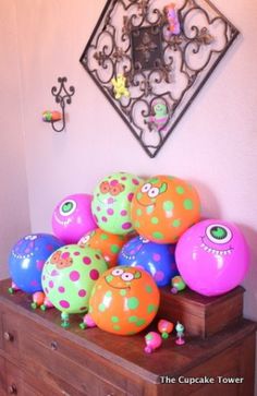 there are many balloons on the dresser in this room, including one that has eyes