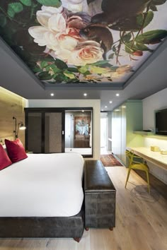 a large bed sitting under a painting on the ceiling