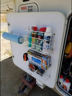 the back end of a camper with its door open and shelves full of camping supplies