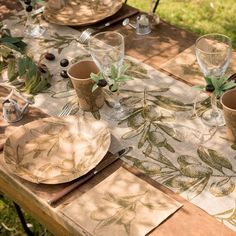 an outdoor table set with place settings and plates