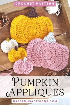 crochet pumpkin appliques on a wooden tray with pine cones and acorns