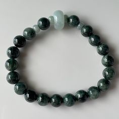 Detail Specification Shape : Round Bead Approx Bead Diameter : 8.5 mm Bead Count : 20+4+1 pcs Weight : 24.5g (122.5 ct) Bracelet size : 16 cm (6.3 in) inner perimeter Color : Dark Green Texture : Medium Transparency : opaque Country of origin : Myanmar (Burma). Cord : Elastic String Jadeite Bracelet Description This Jadeite Jade Bead Bracelet is Free of Treatment from Artificial coloring/bleaching. It occupies various tone of natural dark green color. 20 pieces of round jade dark green beads are Dark Green Texture, Jade Bead Bracelet, Texture Medium, Jade Charm, Green Texture, Green Beads, Natural Jade, Jade Beads, Nature Bracelets