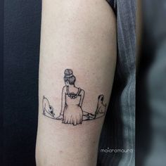 a woman is sitting on the ground with her dog and cat behind her arm tattoo