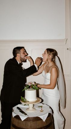 a bride and groom feeding each other cake