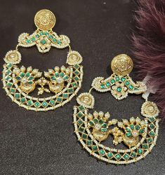 This exquisite Antique Gold Emerald Green Kundan Chandbali set features intricate craftsmanship and timeless elegance. The stunning emerald green stones are beautifully complemented by the antique gold finish, making it a perfect choice for traditional and festive occasions. Add a touch of royal charm to your jewelry collection with this captivating piece. Earrings Description  Approximately 3.5 inches Long Approximately 3 inches wide  A Earring weight is 0.9 oz All our products are crafted using traditional skills from our rich heritage. The manual nature of these crafts means that irregularities or variations are inherent in the handcrafting process. Pakistani Jewelry Bridal, Indian Wedding Earrings, Kundan Chandbali, Earrings Kundan, Emerald Green Stone, Emerald Green Earrings, Green Stones, Pakistani Jewelry, Jewelry Bridal