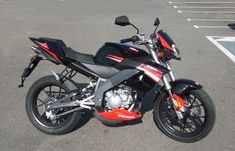 a red and black motorcycle parked in a parking lot