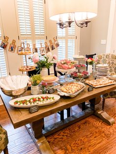 a wooden table topped with lots of food and desserts on it's sides