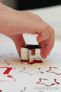 someone is stamping something on a piece of paper with red, white and blue ink