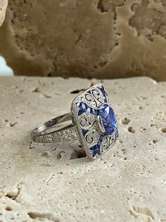 Item Details Model Number: SDL3500BWY Metal: Platinum 850 Weight: 9.1 grams Length: 18 mm (face of ring) Width: 18 mm (face of ring) Style: Art Deco Ring Size: 6.5 (contact us for sizing options) Main Stone Details Main Stone: Sapphire Carat Weight: 3.87 CT, 0.85 CT Shape: Oval, French Cut Color/Clarity: Blue/ Certificate: GGA All of our diamonds and gemstones are 100% natural! Other Diamond Details Carat Weight: 0.85 CT Shape: Round Color/Clarity: F/SI1 Cut: Excellent