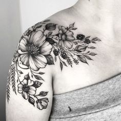 a woman's shoulder with flowers and leaves on the top half of her body