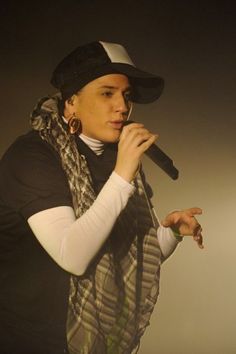 a woman wearing a hat and scarf holding a microphone