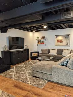 a living room filled with furniture and a flat screen tv on top of a wooden floor