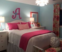 a bedroom with blue walls and pink bedding