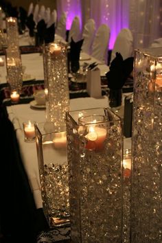 some candles are sitting in vases on a table