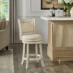 a white bar stool sitting in front of a counter top next to a chair with a bottle of wine on it