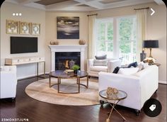 a living room filled with furniture and a fire place in front of a flat screen tv