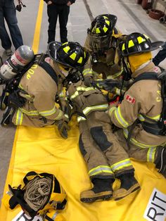 two fire fighters are laying on the ground