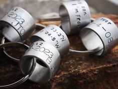 four silver rings with numbers on them sitting on a rock